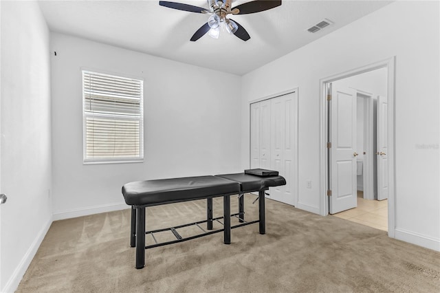 interior space with visible vents, light carpet, baseboards, and a ceiling fan