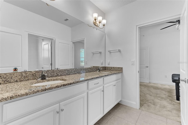 bathroom featuring double vanity, tile patterned flooring, baseboards, and a sink