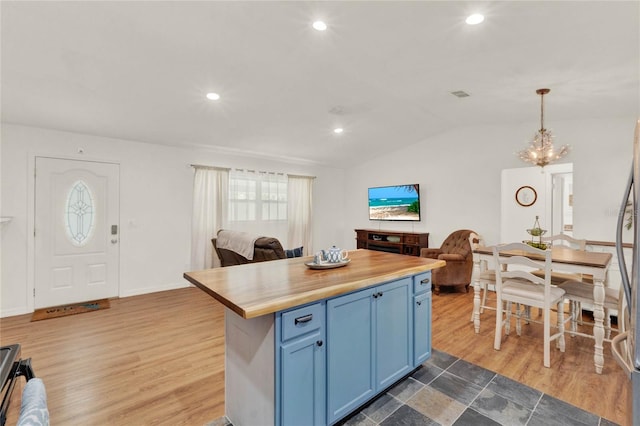 kitchen featuring blue cabinetry, open floor plan, and wood finished floors