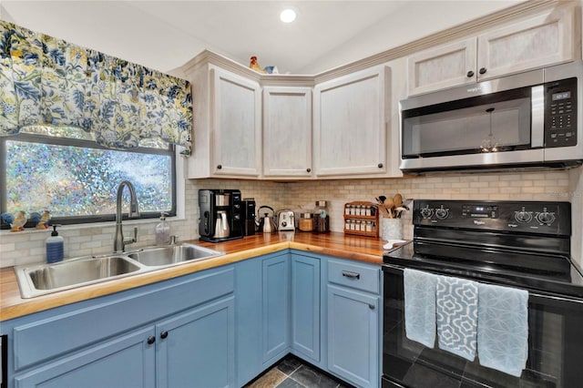 kitchen with black range with electric cooktop, stainless steel microwave, tasteful backsplash, and a sink