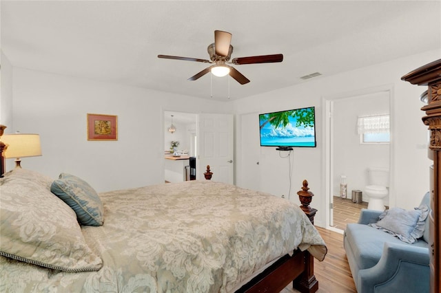 bedroom featuring light wood-style floors, visible vents, ceiling fan, and ensuite bath