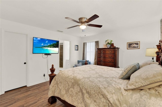 bedroom featuring a ceiling fan, visible vents, and wood finished floors