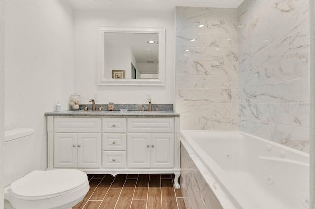 bathroom with a whirlpool tub, toilet, a sink, and wood finish floors