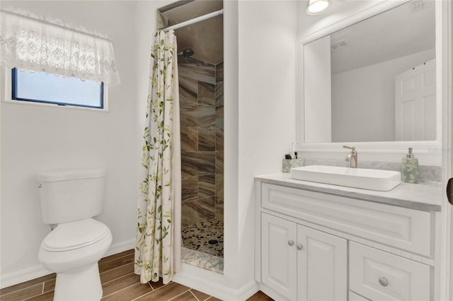 full bathroom featuring toilet, a stall shower, wood tiled floor, and vanity