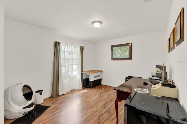 office with a textured ceiling, baseboards, and wood finished floors