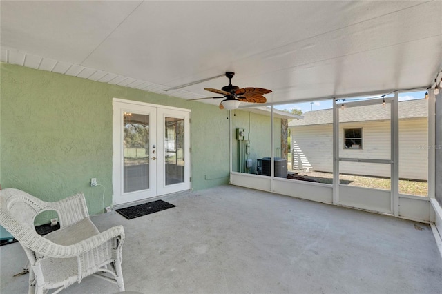 unfurnished sunroom featuring ceiling fan and french doors