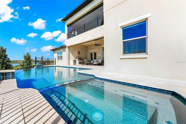 view of swimming pool featuring a patio area, a pool with connected hot tub, a ceiling fan, and french doors