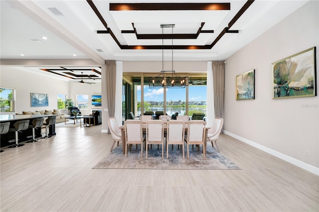 dining room featuring ceiling fan with notable chandelier, a tray ceiling, visible vents, and baseboards