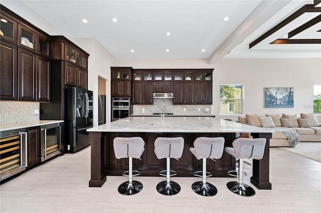 kitchen featuring decorative backsplash, wine cooler, open floor plan, black refrigerator with ice dispenser, and double oven