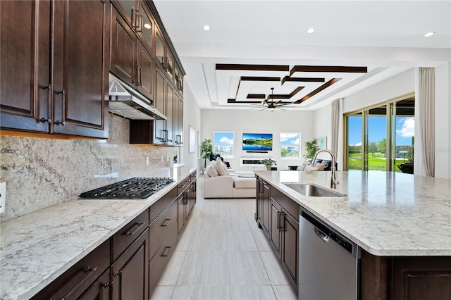 kitchen featuring ceiling fan, under cabinet range hood, a sink, open floor plan, and appliances with stainless steel finishes