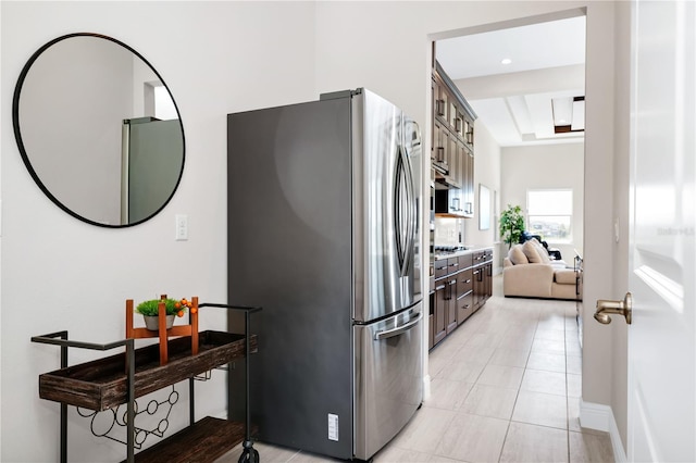 kitchen featuring glass insert cabinets, appliances with stainless steel finishes, light countertops, dark brown cabinets, and light tile patterned flooring