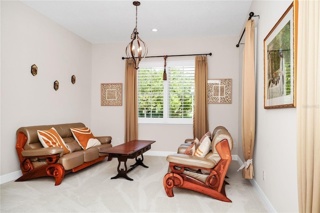 living area with baseboards, a notable chandelier, and light colored carpet