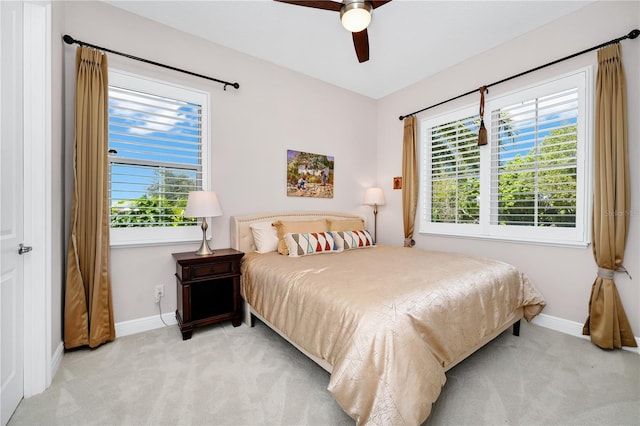 bedroom featuring a ceiling fan, light colored carpet, and baseboards