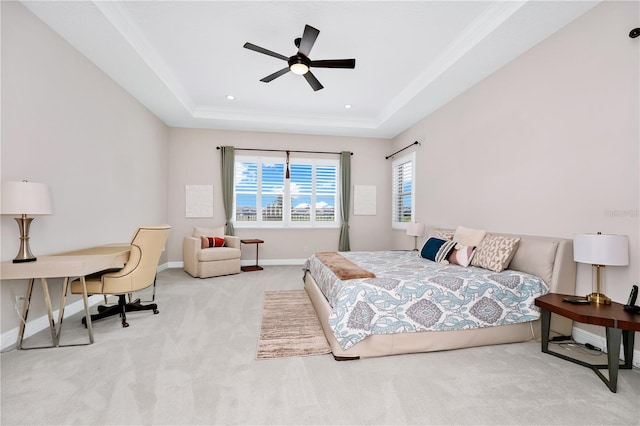 carpeted bedroom with baseboards, a ceiling fan, a tray ceiling, crown molding, and recessed lighting