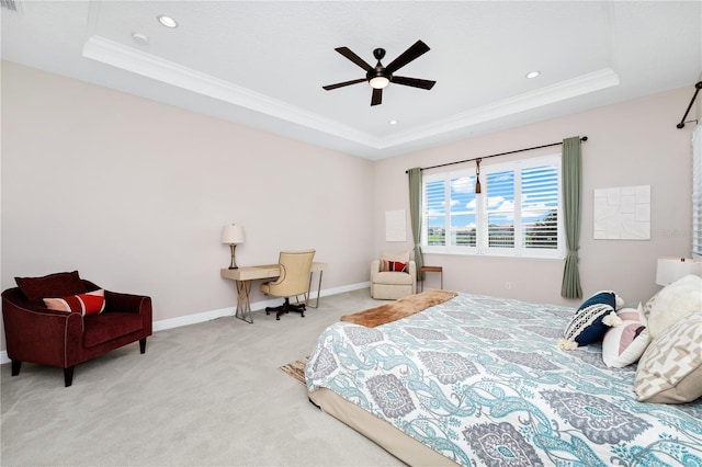 bedroom with ornamental molding, a tray ceiling, and light carpet