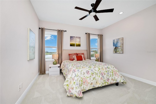 bedroom with light carpet, baseboards, and a ceiling fan