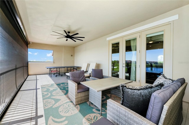 sunroom / solarium with ceiling fan, french doors, and a water view