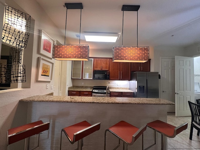 kitchen with a kitchen breakfast bar, fridge with ice dispenser, a peninsula, black microwave, and stainless steel electric range