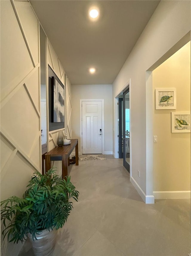 hall with baseboards and recessed lighting