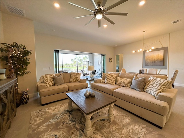 living room featuring recessed lighting, visible vents, baseboards, and ceiling fan with notable chandelier