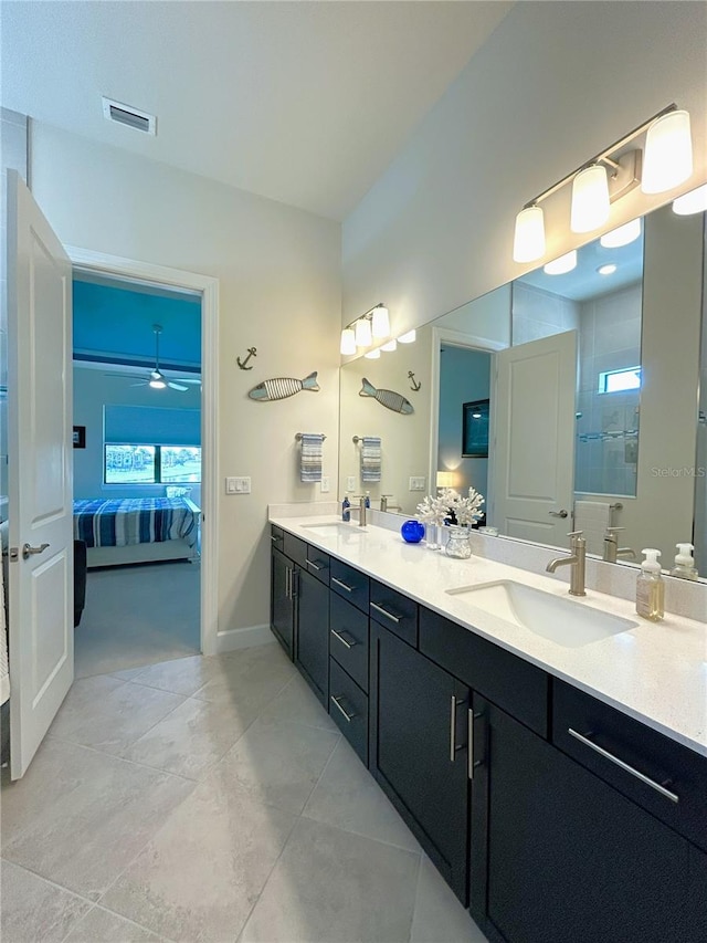 bathroom with double vanity, a sink, visible vents, and connected bathroom