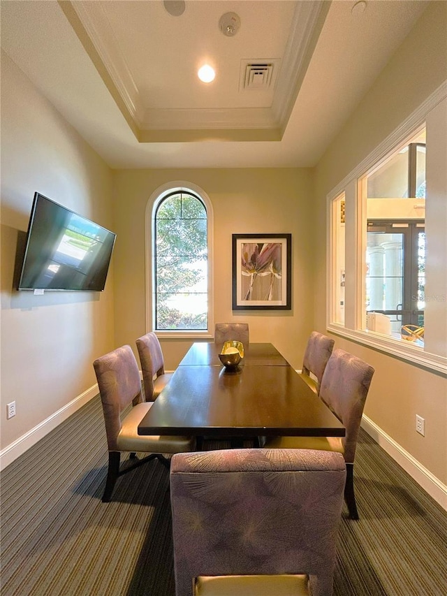 dining space with carpet flooring, a raised ceiling, visible vents, and baseboards