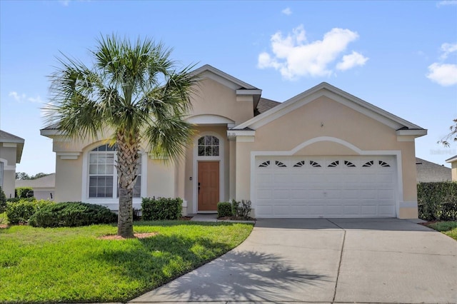 view of front of property with an attached garage, a front yard, concrete driveway, and stucco siding