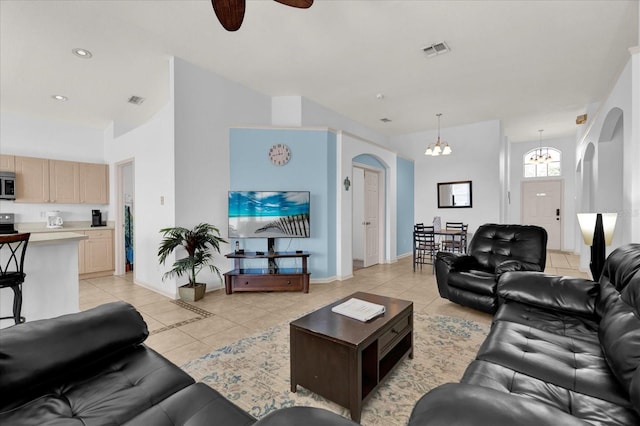 living room with arched walkways, visible vents, and light tile patterned floors