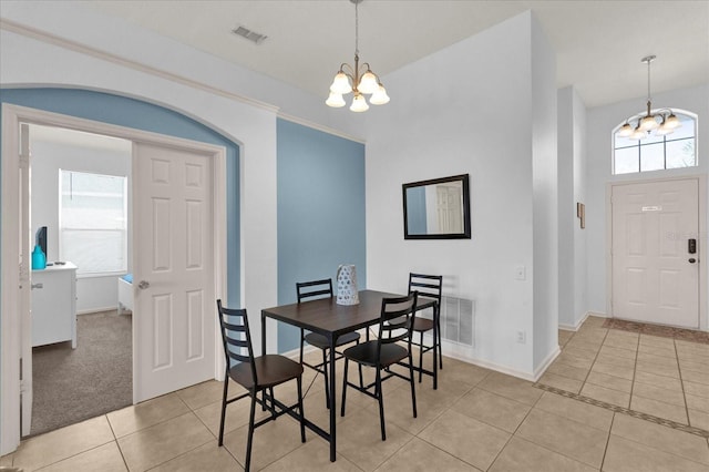 dining area featuring light tile patterned floors, baseboards, visible vents, and a notable chandelier