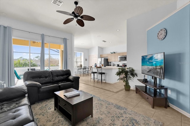 living room with a ceiling fan, visible vents, baseboards, and light tile patterned flooring