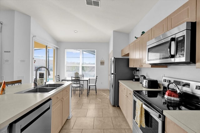 kitchen featuring light tile patterned floors, stainless steel appliances, light countertops, visible vents, and a sink