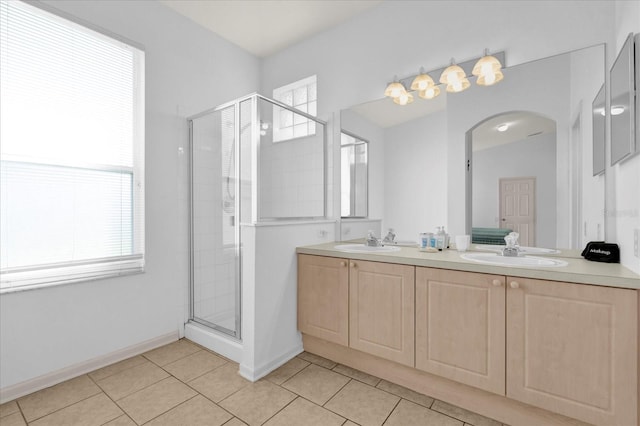 full bath with tile patterned flooring, a sink, a shower stall, and double vanity