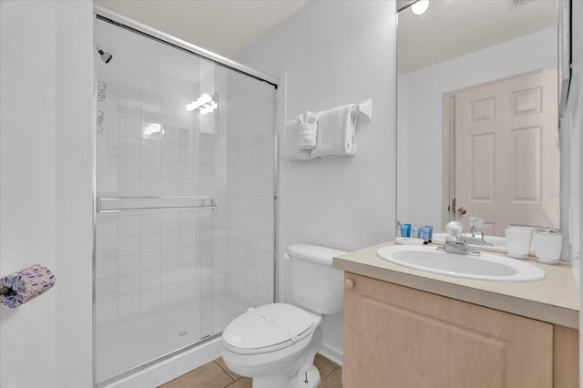 bathroom featuring toilet, a stall shower, vanity, and tile patterned floors