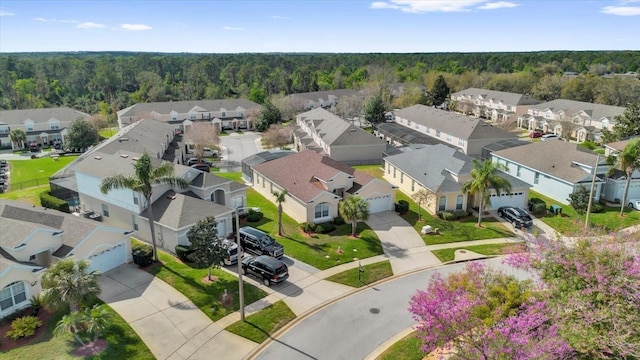 birds eye view of property featuring a wooded view and a residential view