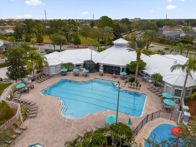 community pool with a patio and fence