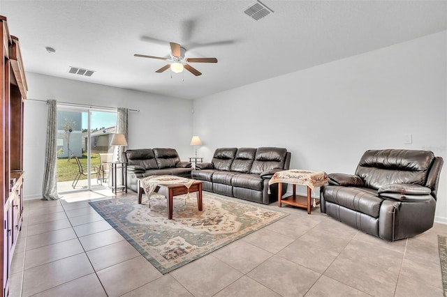 living area with light tile patterned floors, ceiling fan, visible vents, and a textured ceiling