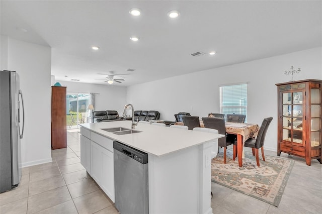 kitchen featuring visible vents, appliances with stainless steel finishes, open floor plan, light countertops, and a sink