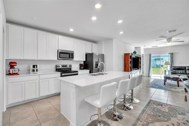 kitchen featuring stainless steel appliances, light tile patterned flooring, a sink, and visible vents