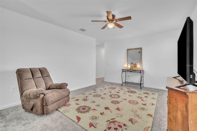 living area featuring light colored carpet, ceiling fan, visible vents, and baseboards