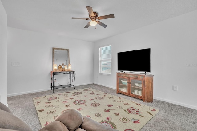 living area featuring carpet flooring, ceiling fan, and baseboards