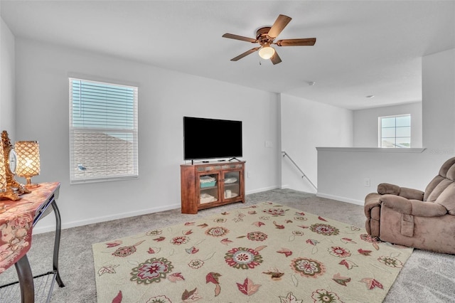 carpeted living room with ceiling fan and baseboards