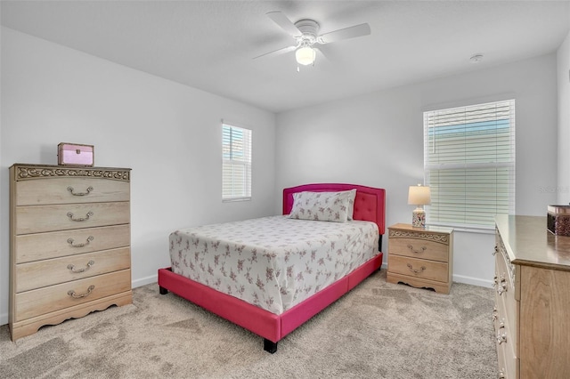 bedroom featuring a ceiling fan, light carpet, and baseboards