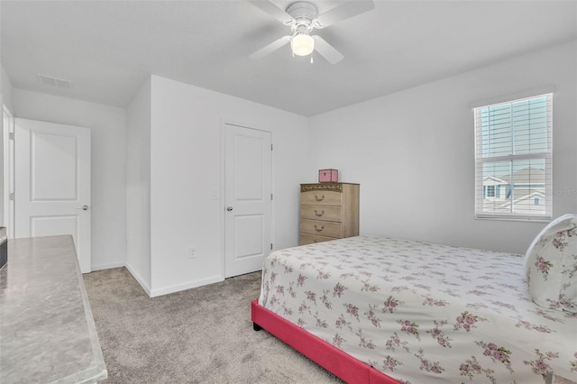 carpeted bedroom with a ceiling fan, visible vents, and baseboards