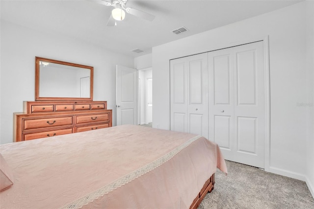 bedroom with light colored carpet, a closet, visible vents, and ceiling fan