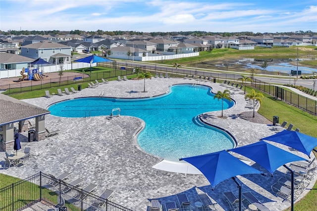 pool featuring a residential view, a patio area, fence, and a lawn