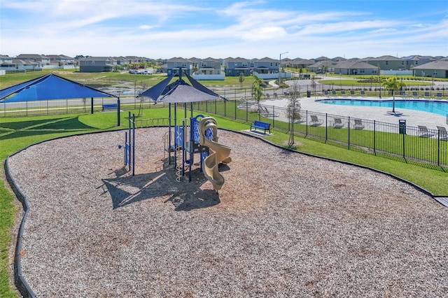 community playground with a residential view, fence, and a yard