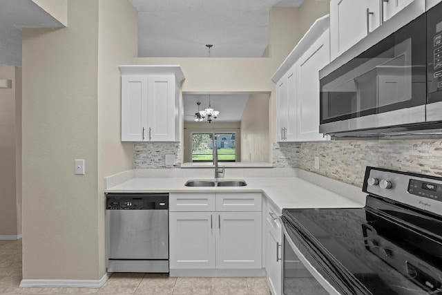 kitchen with a sink, white cabinets, light countertops, appliances with stainless steel finishes, and tasteful backsplash