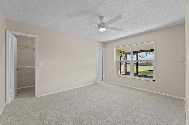 spare room featuring carpet floors, a textured ceiling, and baseboards