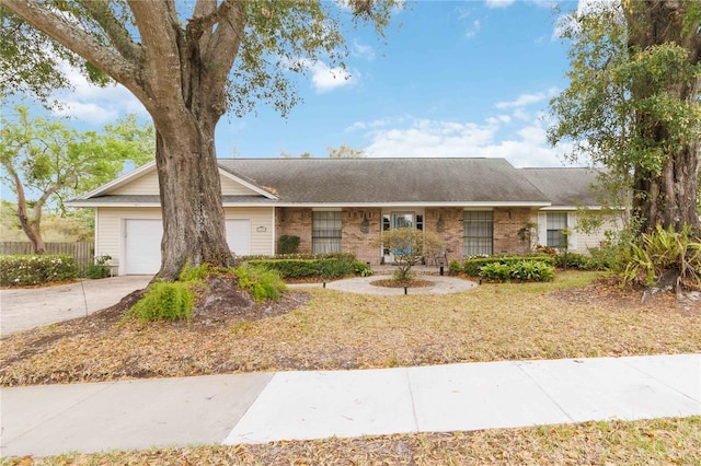 ranch-style home with a garage, driveway, fence, and brick siding