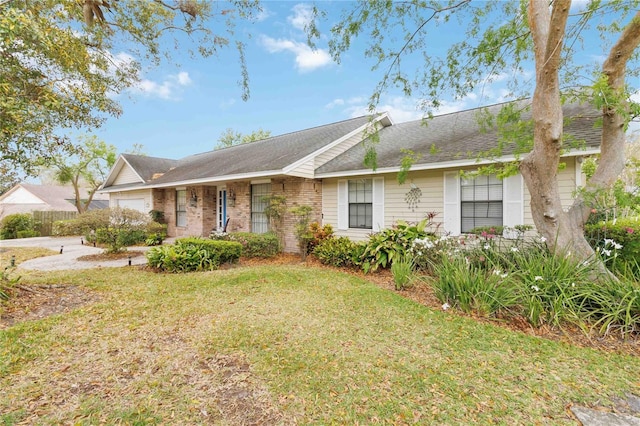 single story home featuring brick siding, a front lawn, and an attached garage